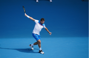 Stan Wawrinka following through on a shot on a hard court
