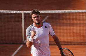 Stan Wawrinka celebrating with a clenched fist on a clay court