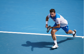Stan Wawrinka following through after a serve on a hard court
