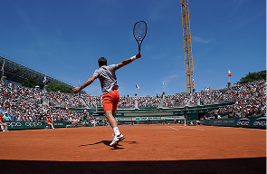 Stan Wawrinka reaching for an overhead on a clay court